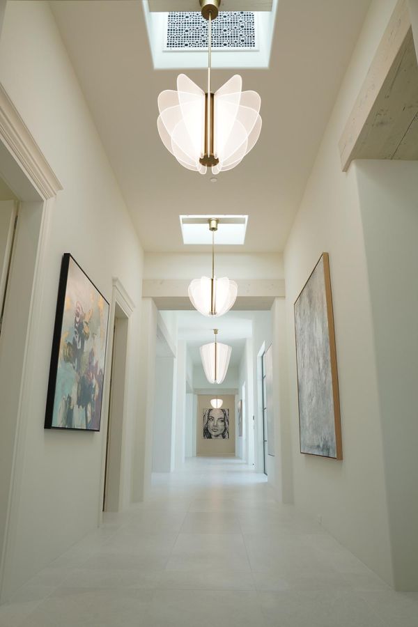 Bright hallway with modern pendant lights and artistic wall paintings