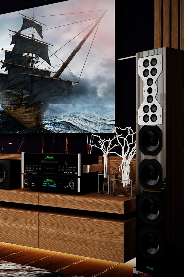 Modern audio setup with large floor-standing speakers and media console under a screen showing a sailing ship